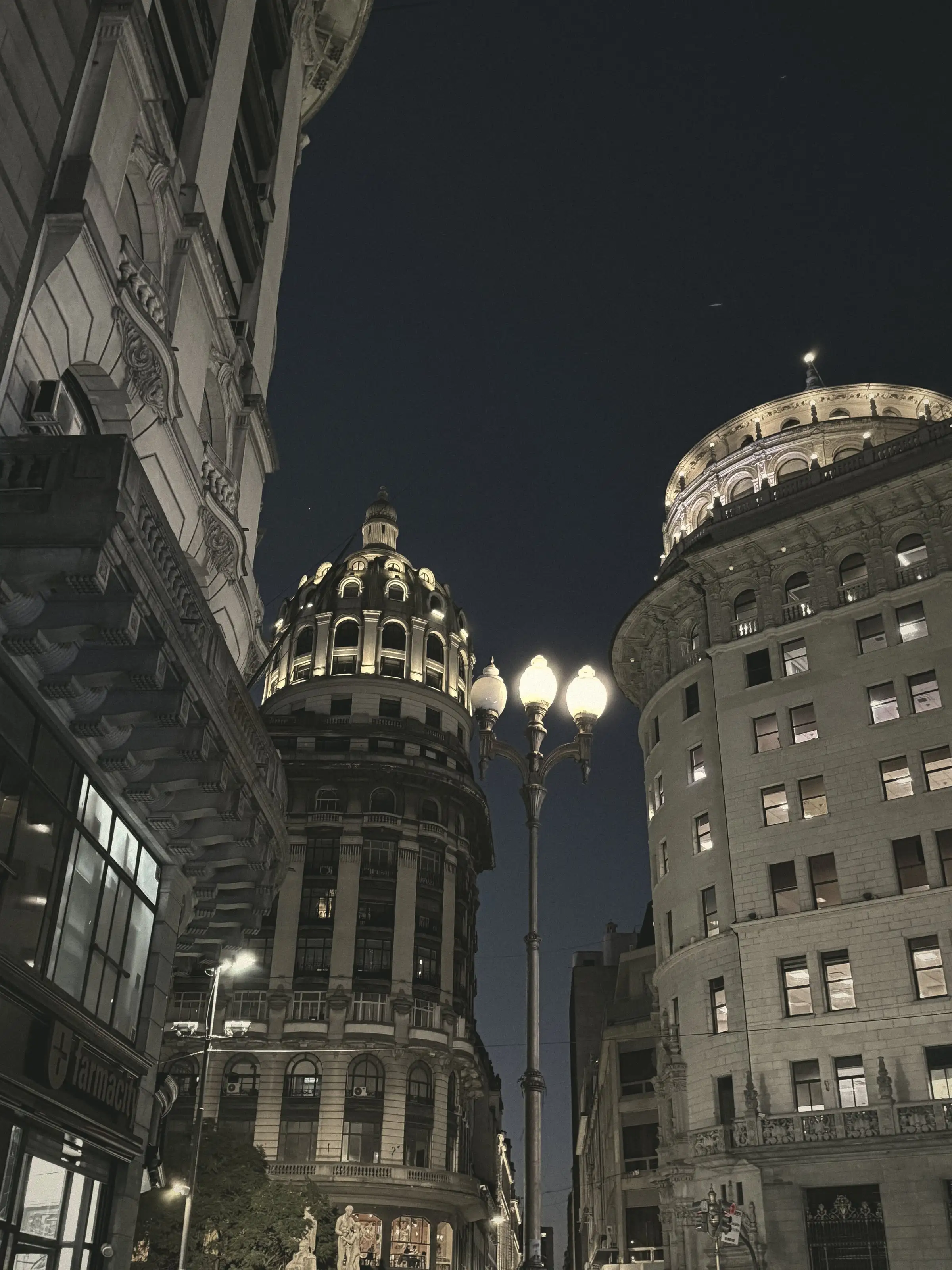 Cúpulas iluminadas y un farol encendido en el centro de Buenos Aires, al anochecer