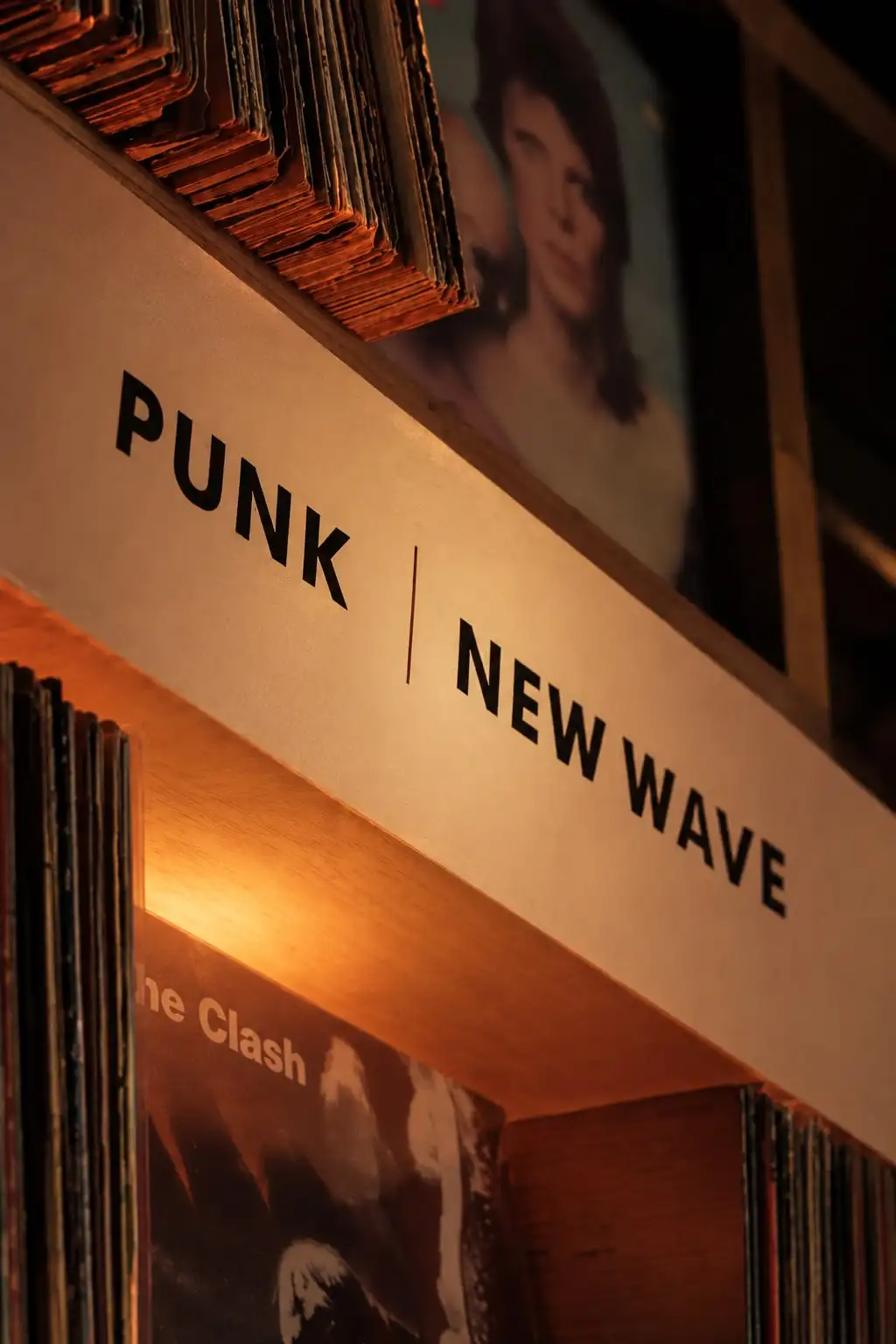 Estante de vinilos con un cartel que separa los géneros «Punk» y «New Wave».